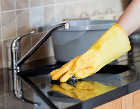 Kitchen deep cleaning with counters and appliances being sanitized